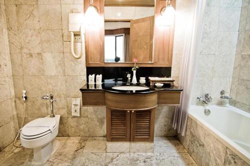 a bathroom with a toilet and a sink and a tub at Laithong Hotel Ubon Ratchathani in Ubon Ratchathani