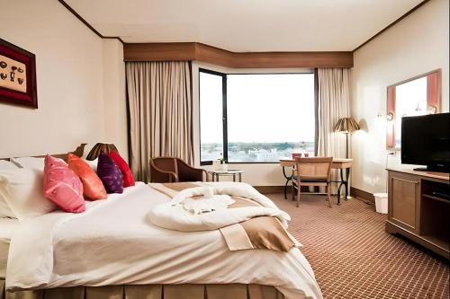 a hotel room with a large bed and a television at Laithong Hotel Ubon Ratchathani in Ubon Ratchathani