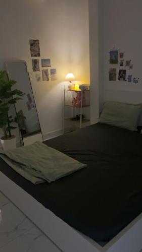 a bedroom with a bed with a mirror and a plant at December homestay studio 002 in Ho Chi Minh City