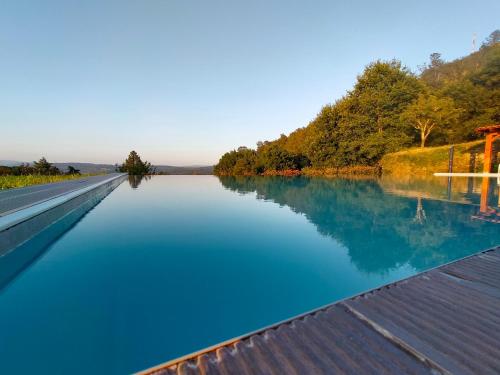 a pool of blue water next to a river at Quinta do Caritel in Vouzela