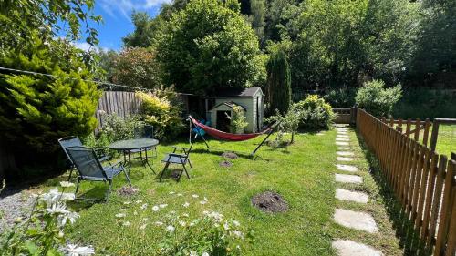 a backyard with a hammock and a table and chairs at River cottage Dartmoor in Holne