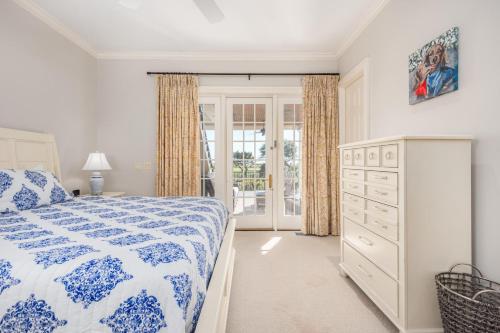 a bedroom with a blue and white bed and a dresser at 15 Ocean Course in Kiawah Island