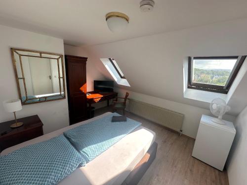 a bedroom with a bed and a desk and a window at Gästehaus am Harz in Goslar