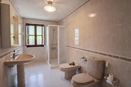 a bathroom with a toilet and a sink at Llanes Casa con Terraza y Barbacoa – La Jorcada in Porrúa