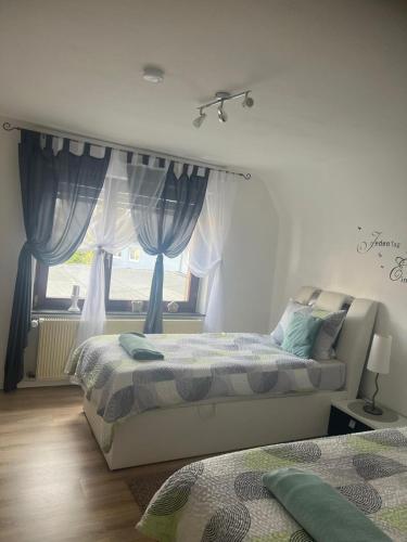 a bedroom with two beds and a window at Beti Apartment in Nentershausen