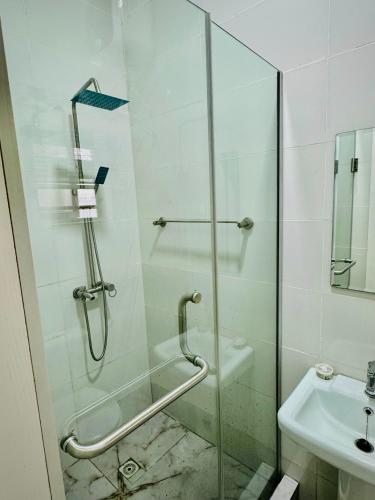 a shower with a glass door next to a sink at Polo Apartments Lekki in Lekki