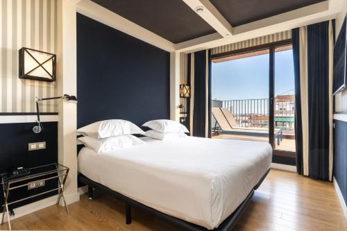 a bedroom with a large white bed and a large window at Europark in Barcelona