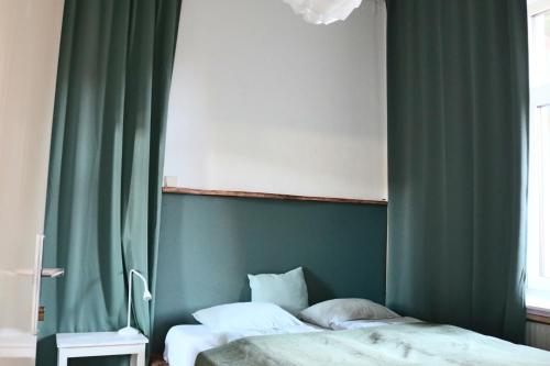 a bedroom with two beds and a green curtain at Apartment Hans - Wohnen im Herzen des Drautales in Feistritz an der Drau
