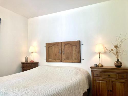 a bedroom with a bed and a cabinet and two lamps at Villa hortus mariae in Le Thoronet