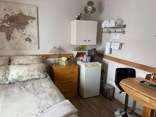 a bedroom with a bed and a desk and a deskablish at Gite La Ptite Falaise hébergement touristique et appartement in Sainte-Anne-des-Monts