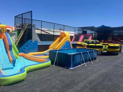 a group of slides and a table in a playground at hostal y centro de eventos in Chorrillos