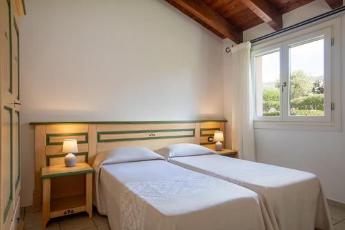 a bedroom with two beds and a window at Sole d'Estate Agriresidence in Costa Rei