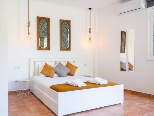 a white bedroom with a white bed with orange pillows at Paço no Monte by Stay ici in Montargil
