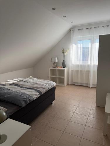 a white bedroom with a bed and a window at Ferienwohnung in Staufenberg- Treis in Staufenberg