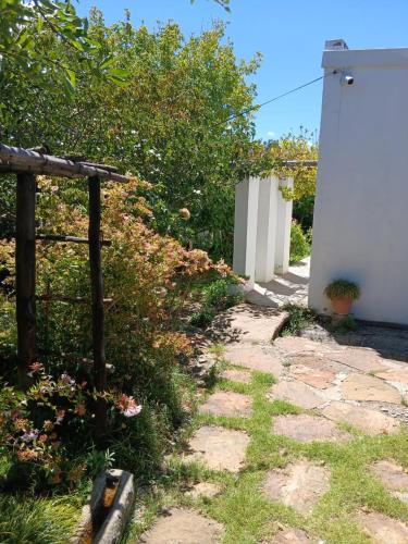 a garden with a stone path and a fence at Olive's Cottage in Molteno