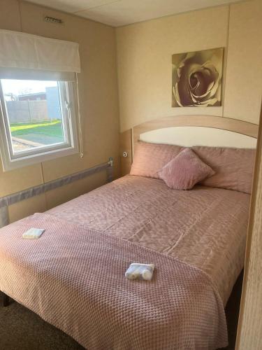 a bedroom with a bed with two towels on it at 159 Summerfields in Great Yarmouth