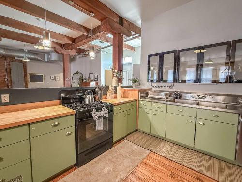 a large kitchen with green cabinets and a stove at Loft 40 in Cleveland
