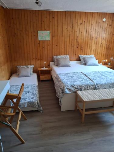 a room with two beds and a chair in it at Prenočišče Breza in Radovljica