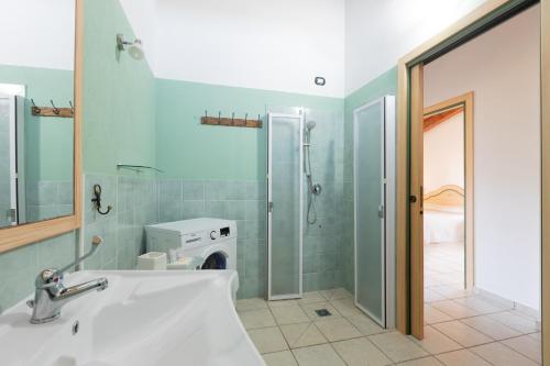 a bathroom with a sink and a washing machine at Sole d'Estate Agriresidence in Costa Rei