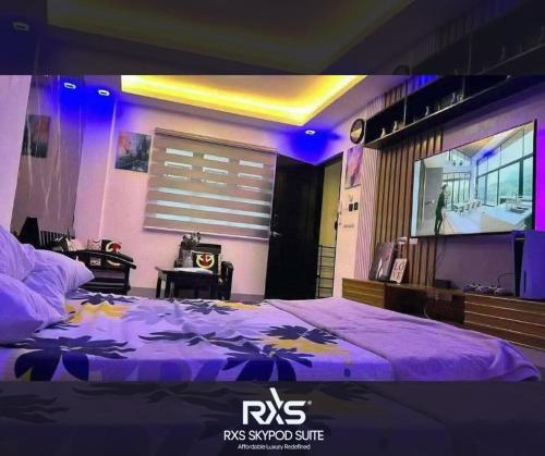 ein Schlafzimmer mit einem lila Bett und einem Fernseher in der Unterkunft RXS SkyPod #3 Suite Condotel - Roxas City in Roxas City