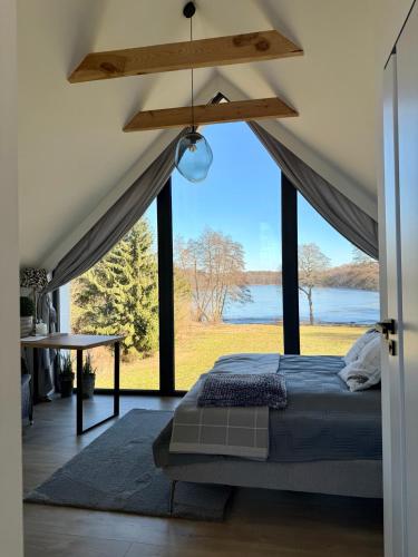 a bedroom with a bed and a large window at Ostoja Dębowa Studnica in Studnica