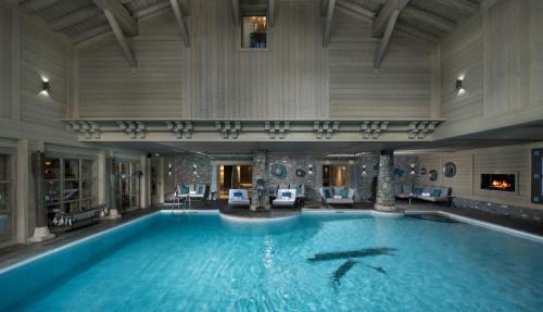 a large swimming pool with two dolphins in a building at Hotel Le K2 Altitude in Courchevel