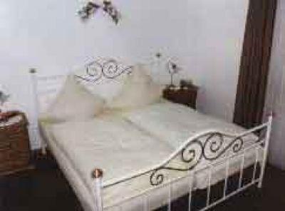 a white bed with white sheets and pillows at Kämpgens – Hof in Mülheim an der Ruhr