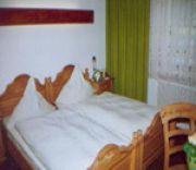 1 dormitorio con cama blanca y cabecero de madera en Kämpgens – Hof en Mülheim an der Ruhr