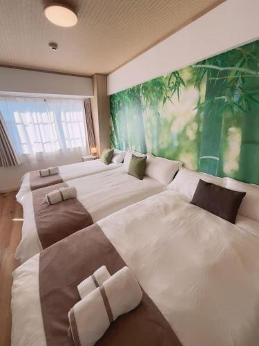 a large bedroom with three beds and a large window at Lucky民泊 in Osaka