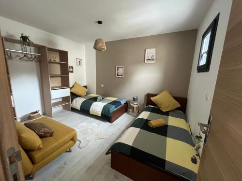 a bedroom with two beds and a couch at Maison familiale La Casa de la Cayote in Formiguères