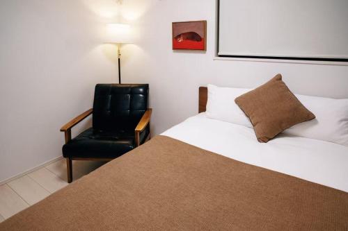 a bedroom with a bed and a black chair at Tokyo stay 365 in Tokyo