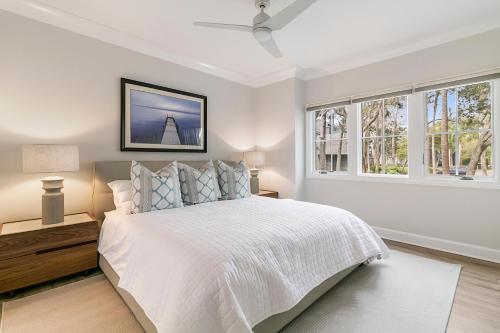 a white bedroom with a bed and two windows at 4910 Green Dolphin in Kiawah Island