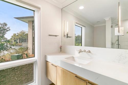 a white bathroom with a sink and a window at 4910 Green Dolphin in Kiawah Island