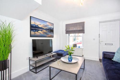 a living room with a blue couch and a tv at Knavesmire Mews 3 bedrooms-Free parking in York