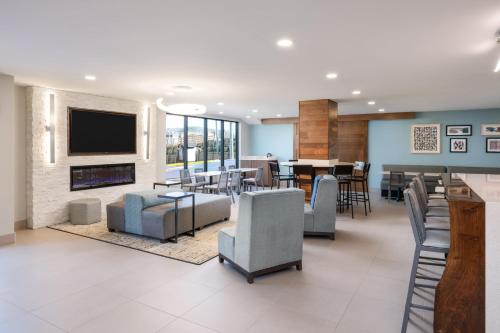 a living room with a television and a dining room at Garner Hotel Pigeon Forge Downtown by IHG in Pigeon Forge