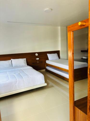 a bedroom with two beds and a mirror at oceanic suítes in Araruama
