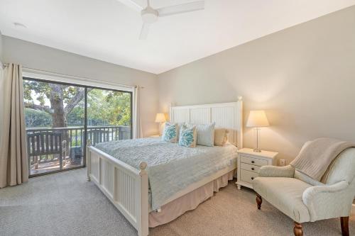 a bedroom with a bed and a window and a chair at 4925 Green Dolphin in Kiawah Island