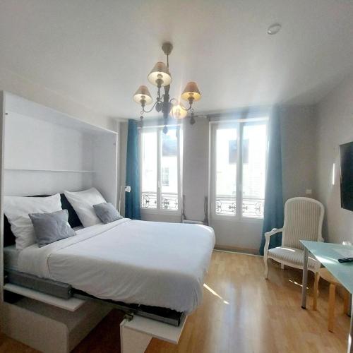 a bedroom with a large white bed and two windows at Studio de Rêves -SV245- Centre Vincennes in Vincennes