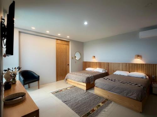 a bedroom with two beds and a table and a desk at "Casa Mosso" en San Felipe del Agua in Oaxaca City