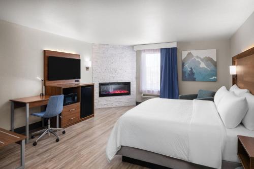 a hotel room with a bed and a desk and a tv at Garner Hotel Pigeon Forge Downtown by IHG in Pigeon Forge