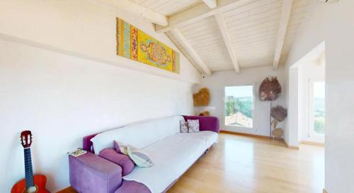a living room with a white couch and a guitar at Casa Nina in Gabicce Mare