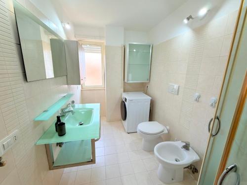 a bathroom with a sink and a toilet at Meduse Seafront - Attico al Mare in Torvaianica