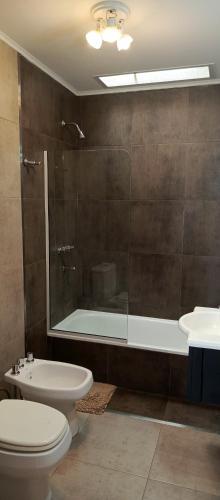 a bathroom with a shower and a toilet and a sink at Departamento duplex in Concordia