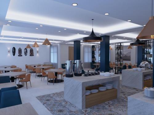 a restaurant with tables and chairs and a kitchen at Luxora Hotel Lodwar in Lodwar