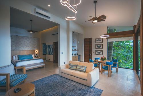 a bedroom with a bed and a living room with a couch at Los Altos Resort in Manuel Antonio
