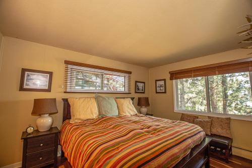 a bedroom with a bed and two windows at Coates By Hauserman Rentals in Tahoe City