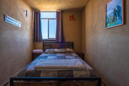 a small bedroom with two beds and a window at Cuanax hotel boutique tematico - Mineral de Pozos in Mineral de Pozos