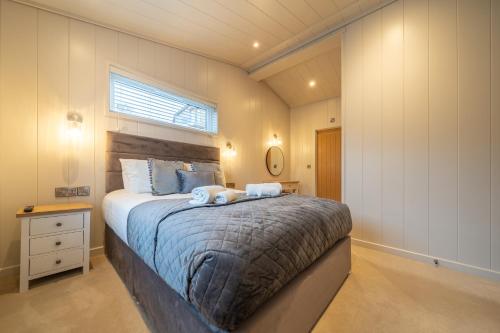a bedroom with a large bed with two towels on it at Park Lodge in Penrith