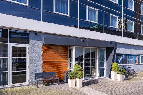 a blue building with a bench in front of it at Holiday Inn Express Antwerpen City North by IHG in Antwerp