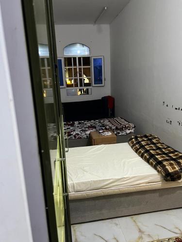 a reflection of a room with two beds and a mirror at BRAZIL House in Muscat